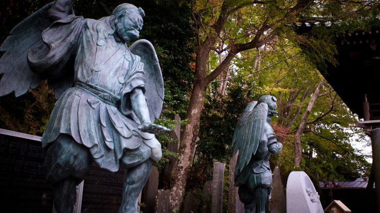 Statues de Tengu dans une forêt japonaise